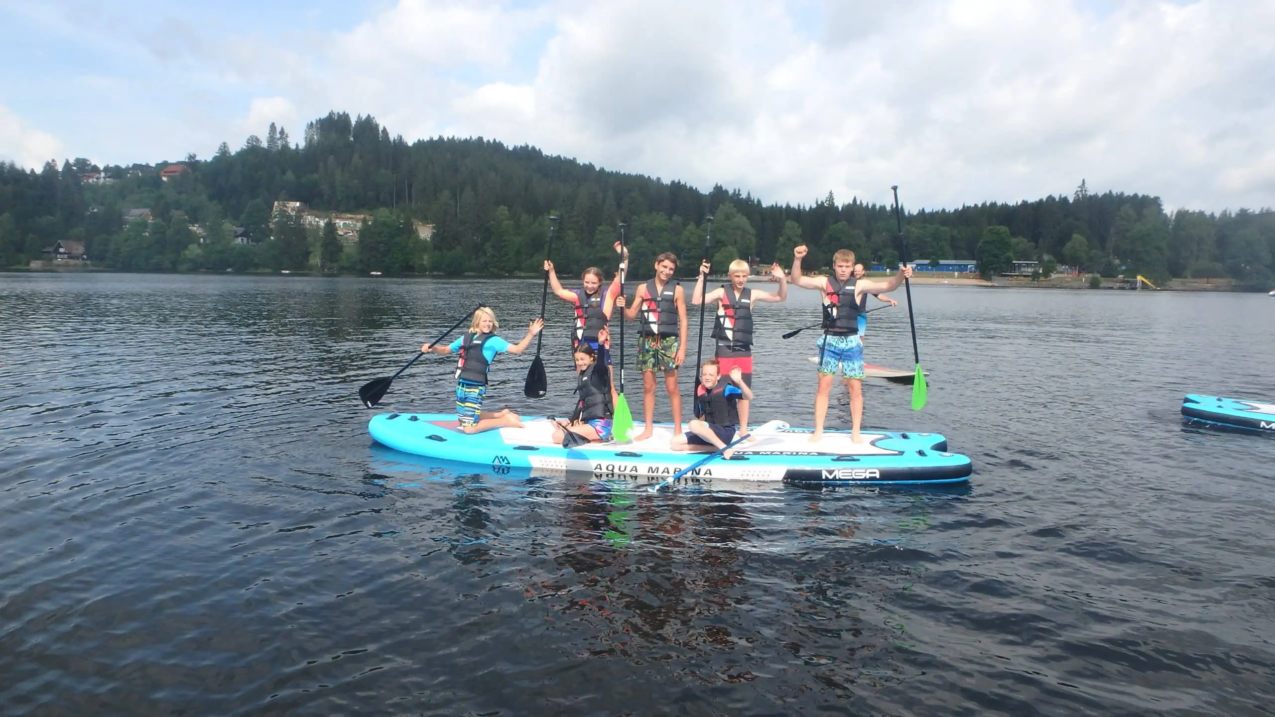 Kinder haben Spaß auf einem Stand Up Paddling Board