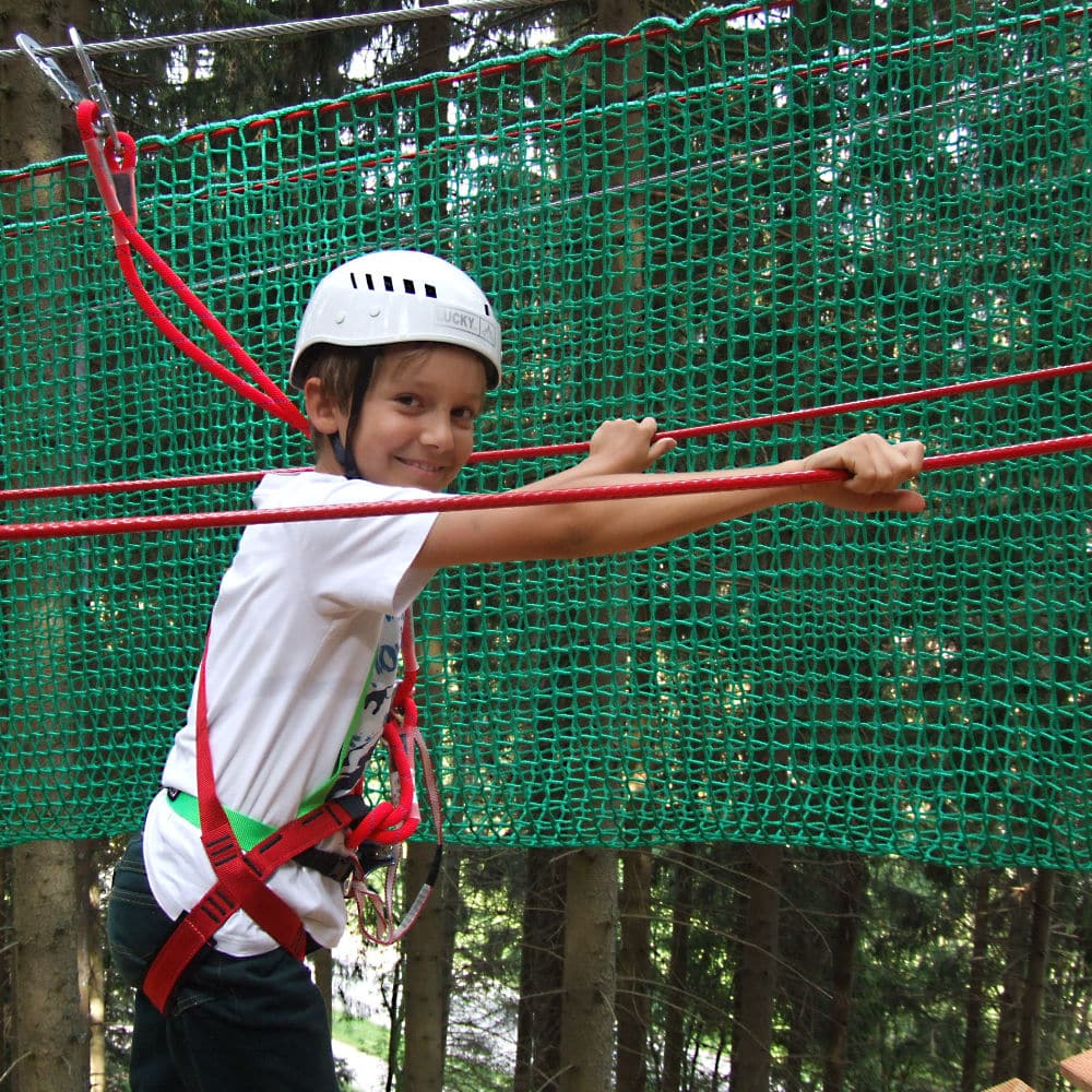 Nahaufnahme von einem Jungen im Kletterwald