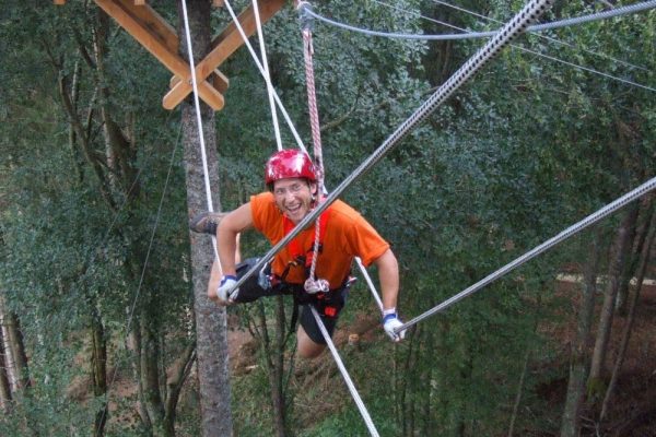 Mann auf Kletterseil im Kletterwald