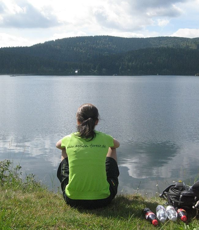 Frau sitz am Ufer des Titisee im Schwarzwald