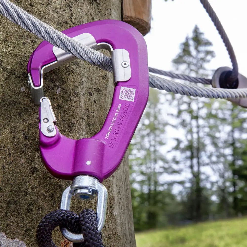 Nahaufnahme eines Klette-Karabiner am Drahtseil im Kletterwald